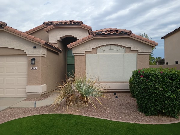 Single-story Florence home with exterior sun screens covering an arched window and standard windows