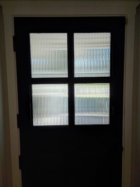 Ribbed decorative window film applied to a glass door for privacy and texture