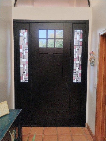 Front door sidelights featuring a colorful stained-glass style decorative window film