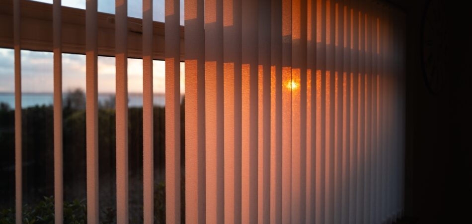 Shallow,focus,on,vertical,window,blinds,with,a,golden,glow