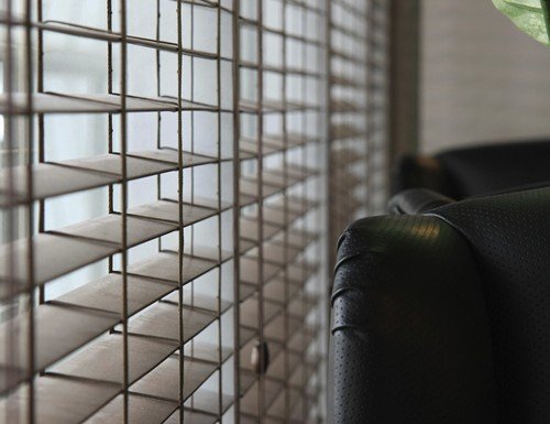 Close-up of horizontal wood blinds with light filtering through the slats